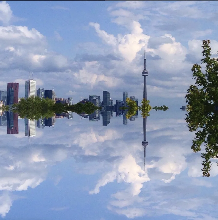Toronto skyline mirrored beneath a cloud-filled sky