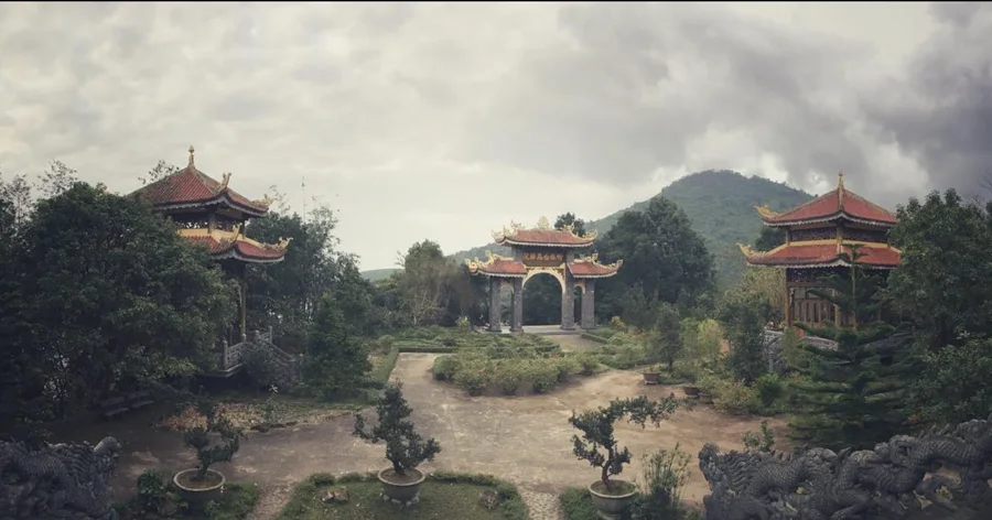 Ornate temple gateways surrounded by trees and mountains