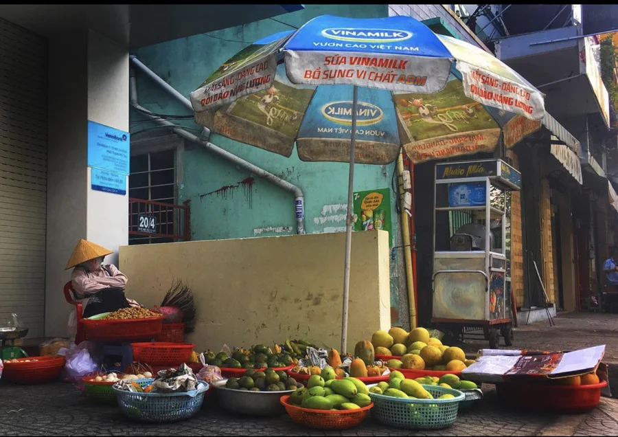 Baskets of fruit beneath a blue market umbrella