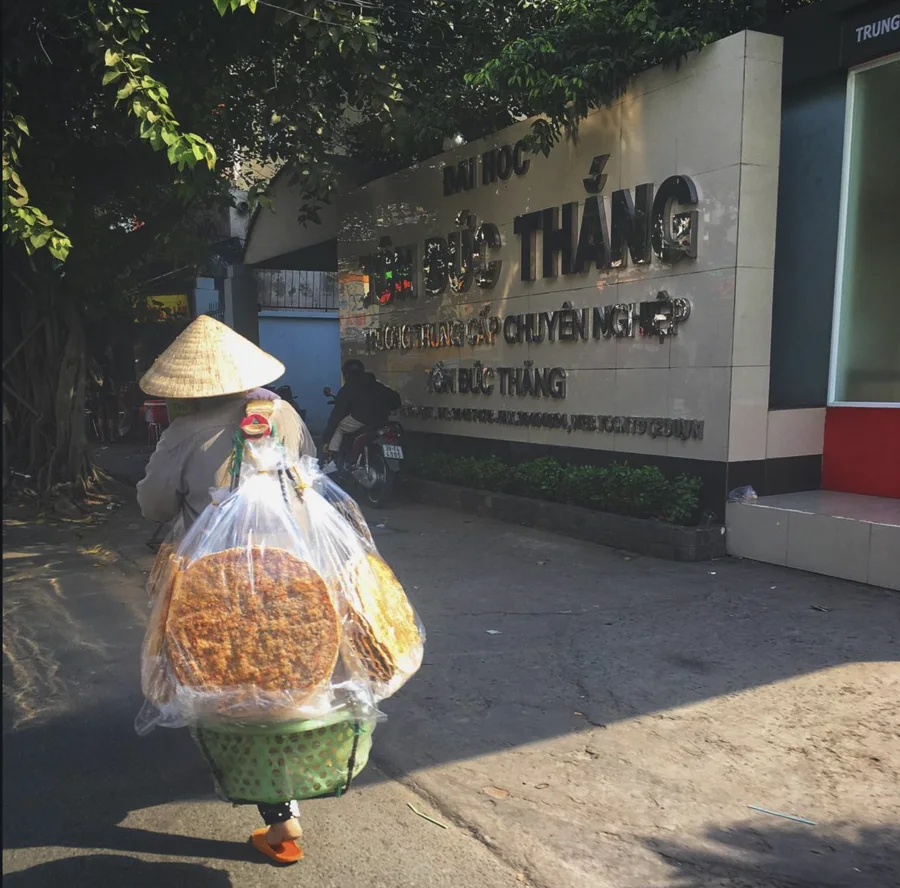 A street vendor carrying baskets and packaged goods