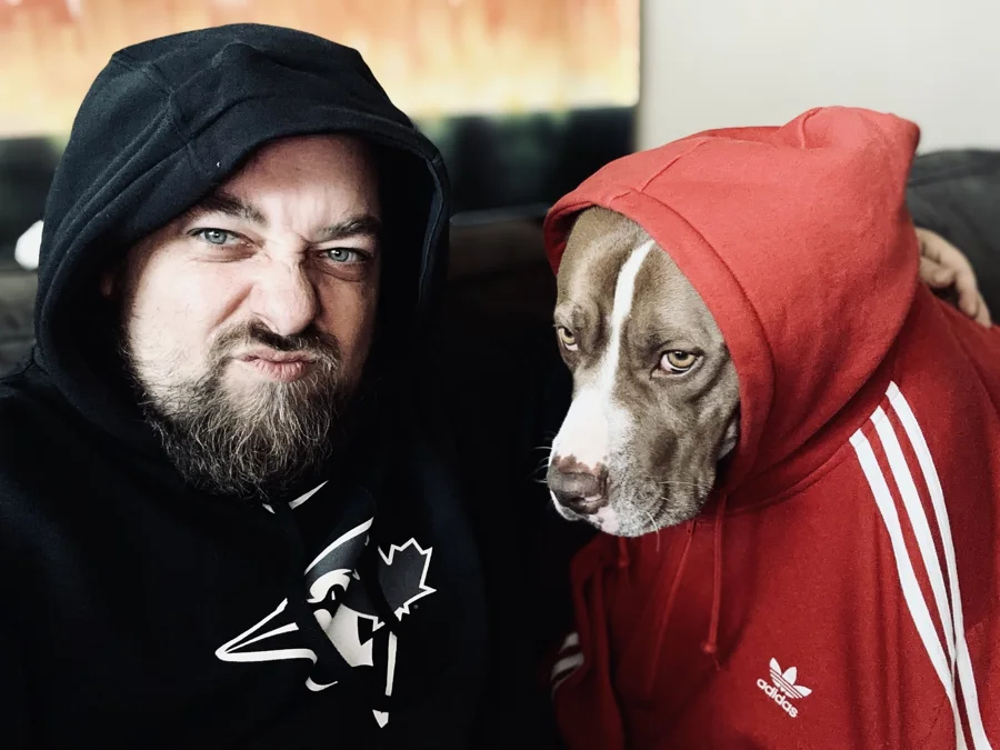 Tony in a red hoodie beside a man in a black hoodie