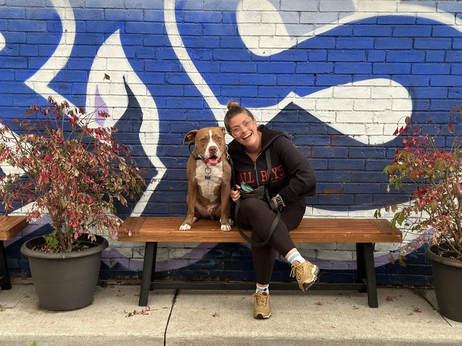 Tony with a woman in front of a blue mural